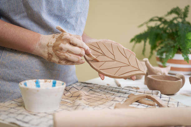istock woman forming leaf shaped clay by hands, closeup in artistic studio 1849508327