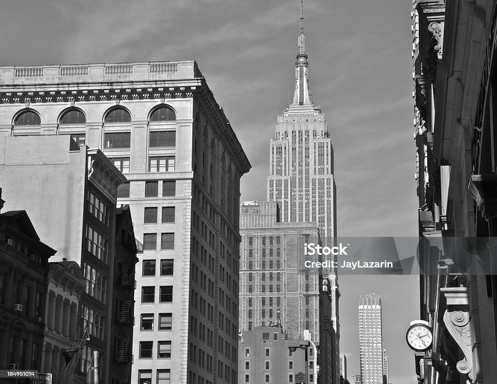Manhattan cityscape view with Empire State Building, NYC The Empire State Building towers over other structures along 5th Avenue at 34th Street. Photographed from below 23rd Street and 5th Ave, Manhattan, New York City. 1930-1939 Stock Photo