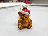 A New Year's toy brown bear in the red hat of Santa Claus. Festive design and decor .