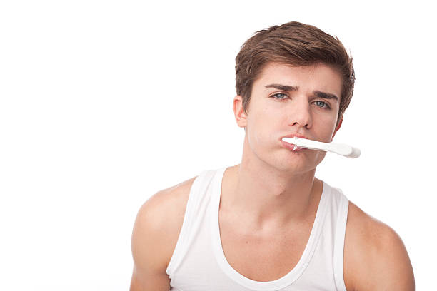 молодые мужчины, мыть его зубьев - brushing teeth healthcare and medicine cleaning distraught стоко�вые фото и изображения