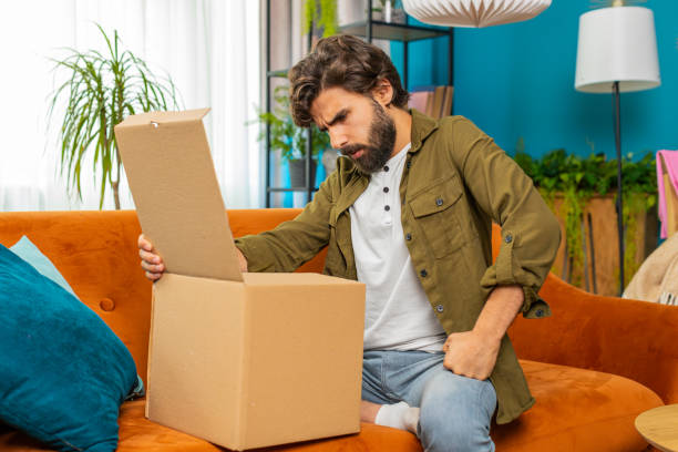 istock Angry dissatisfied shopper middle eastern man unpacking parcel feeling upset confused wrong delivery 1849524174
