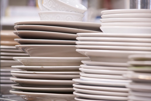 stacks of white china dishes at a second-hand store