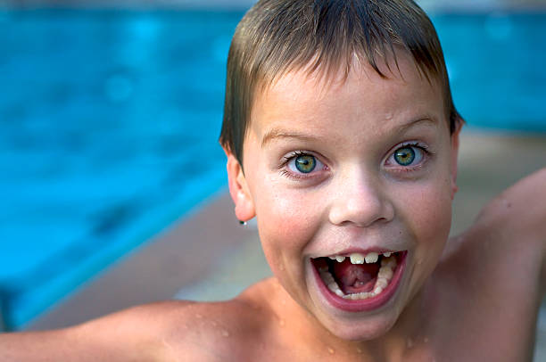 un garçon faisant face à la piscine - screaming little boys child human teeth photos et images de collection