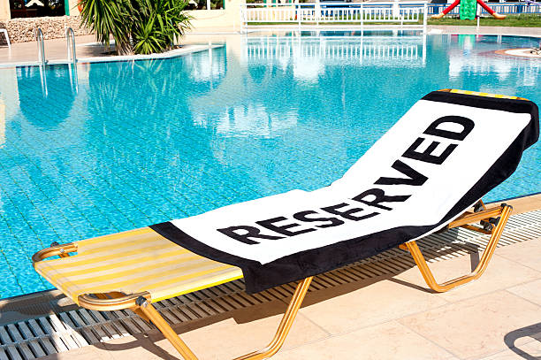 reserved'strandtuch auf einer sonnenliege - strandhandtuch stock-fotos und bilder