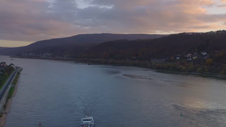 Drone aerial view of Rhine river with boats at sunset in Germany