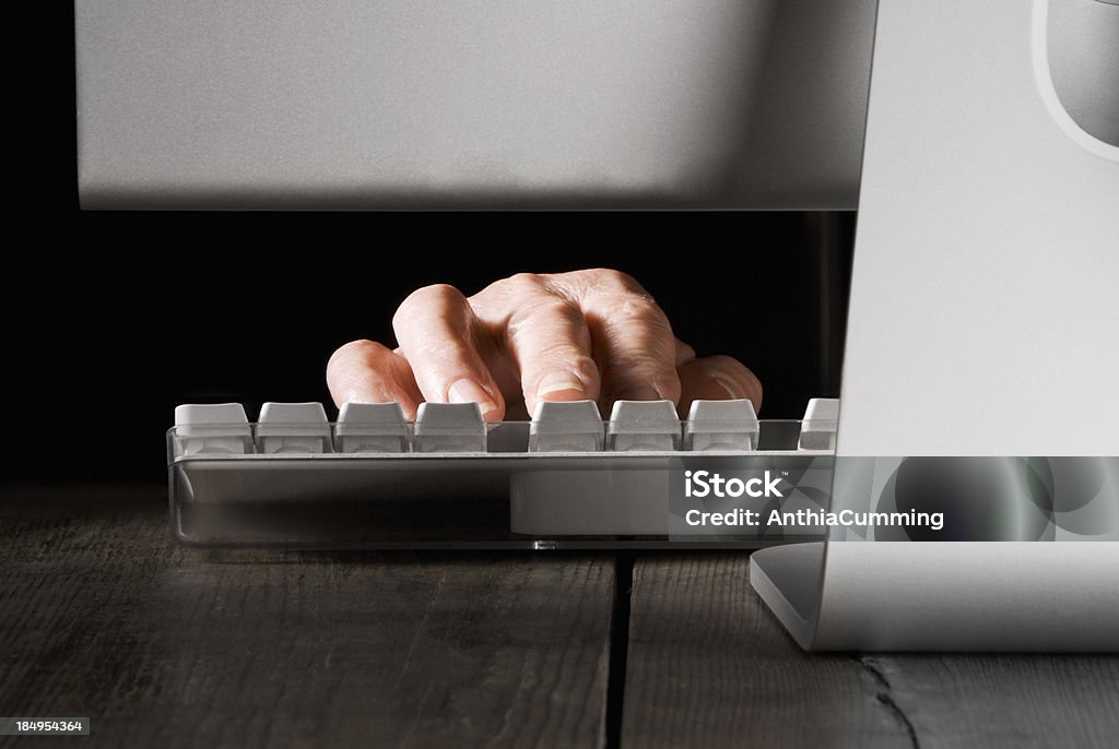 Mãos digitando no teclado do computador à luz atrás de - Foto de stock de Defraudar royalty-free