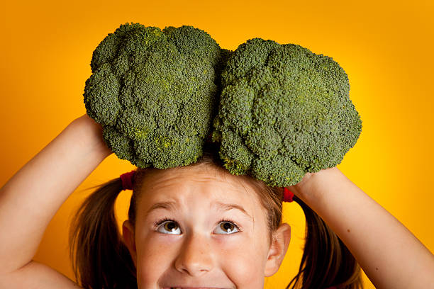 istock Excited Young Girl Holding Broccoli on Her Head 184954449