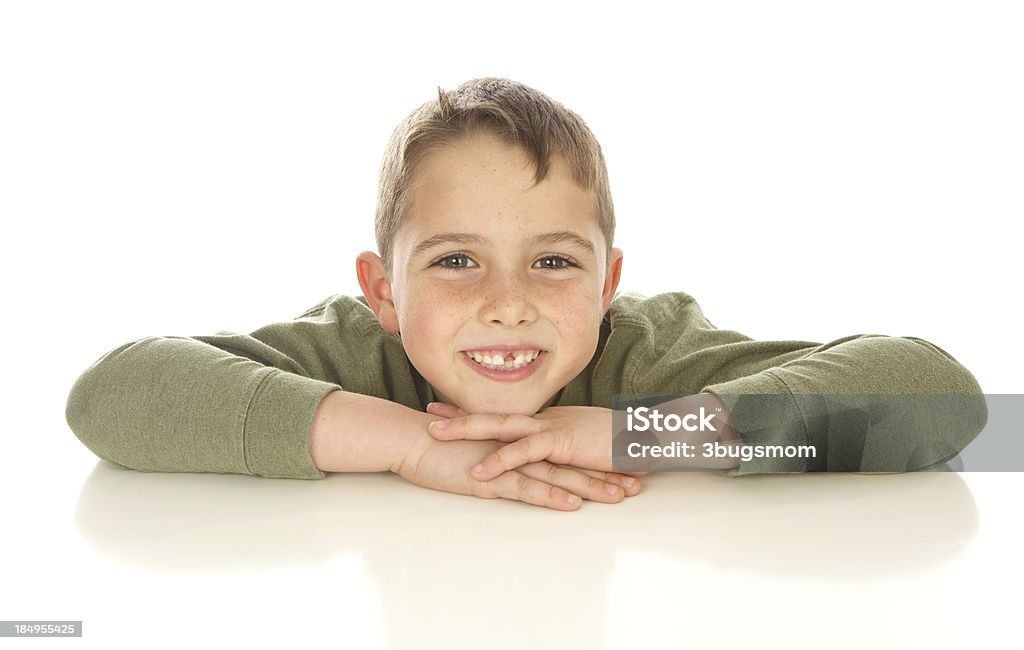 Niño atractivo mirando sobre blanco mesa - Foto de stock de 6-7 años libre de derechos