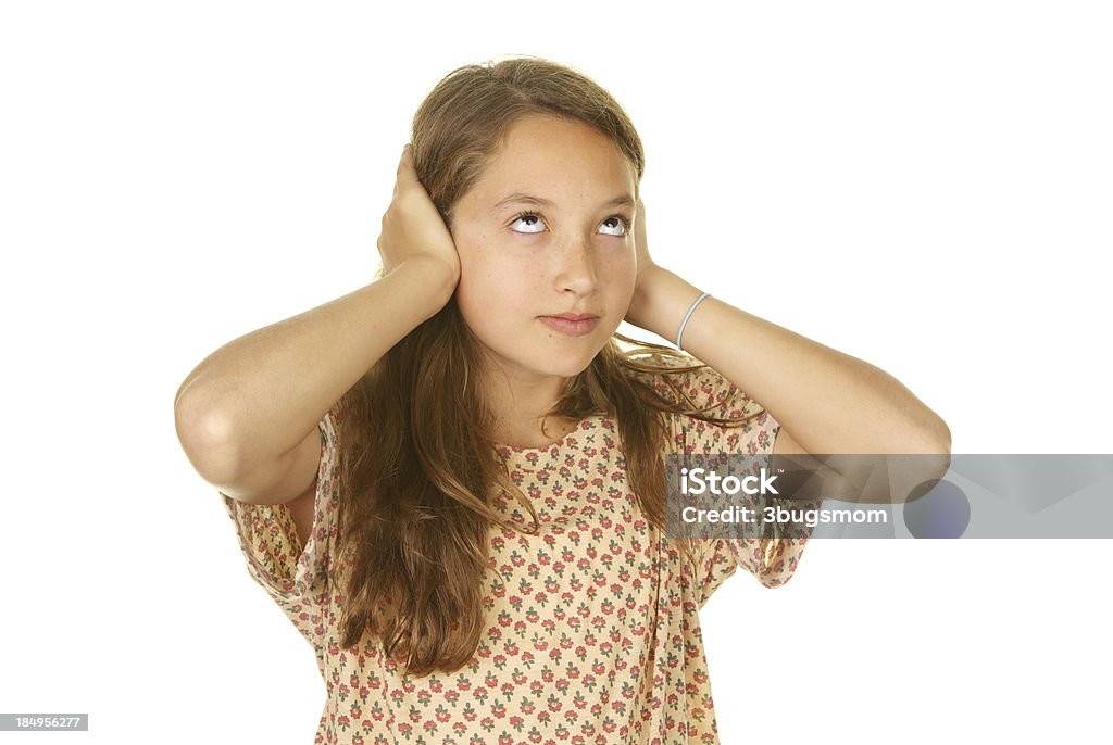 Twelve Year Old Girl not Listening and Rolling Her Eyes A cute preteen girl is covering her ears and rolling her eyes up as if ignoring someone Hands Covering Ears Stock Photo