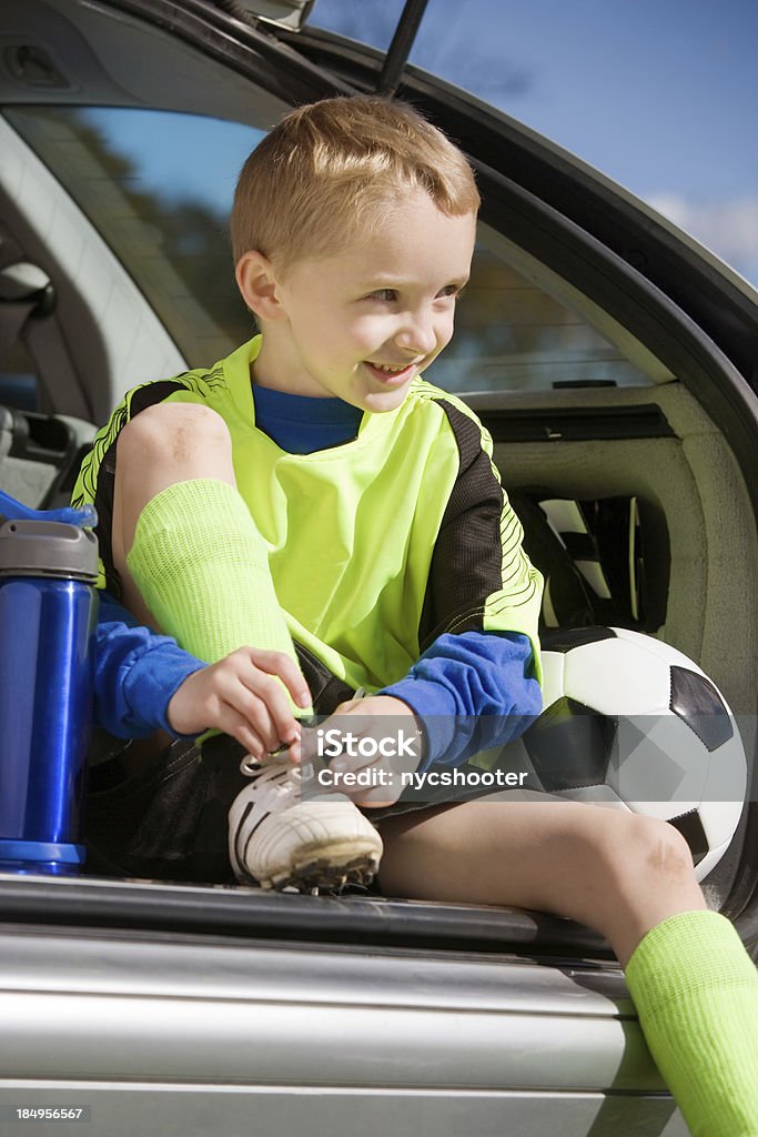 Ragazzo Annodare il calcio con tacchetti - Foto stock royalty-free di Bambino