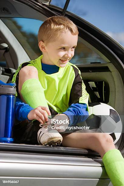 Ragazzo Annodare Il Calcio Con Tacchetti - Fotografie stock e altre immagini di Bambino - Bambino, Automobile, Sportello del portabagagli