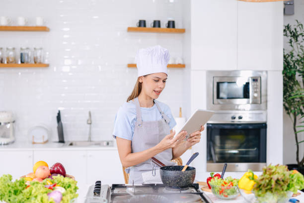 woman online learning cook from tablet at home kitchen modern people with technology lifestyle concept
