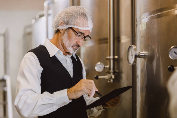 istock Winemaker professional working in modern large winery factory liquor alcohol drinks industry quality control and fermentation monitor vintage color tone 1849568527