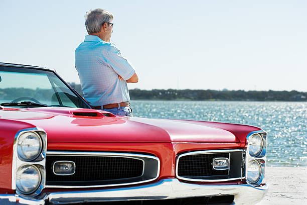 istock Senior with classic convertible car 184957634