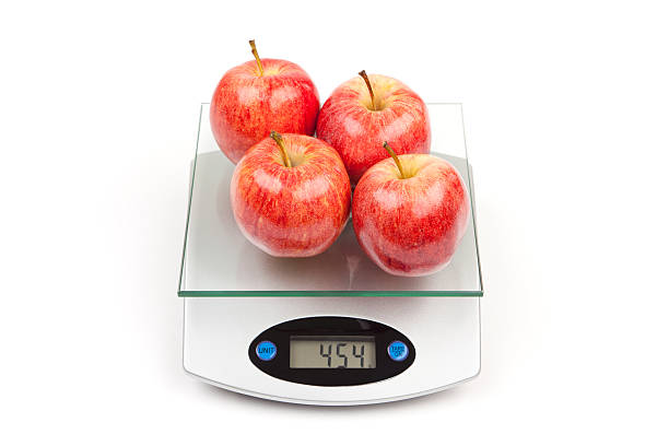 cuatro manzanas en una cocina de dieta escala - weight scale apple comparison balance fotografías e imágenes de stock