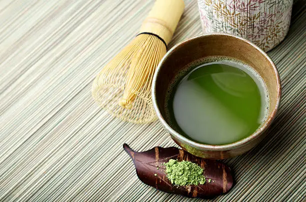 "SEVERAL MORE IN THIS SERIES. Freshly whisked powdered green tea (matcha) with cherrywood scoop, bamboo whisk and tea canister.  Very shallow DOF."