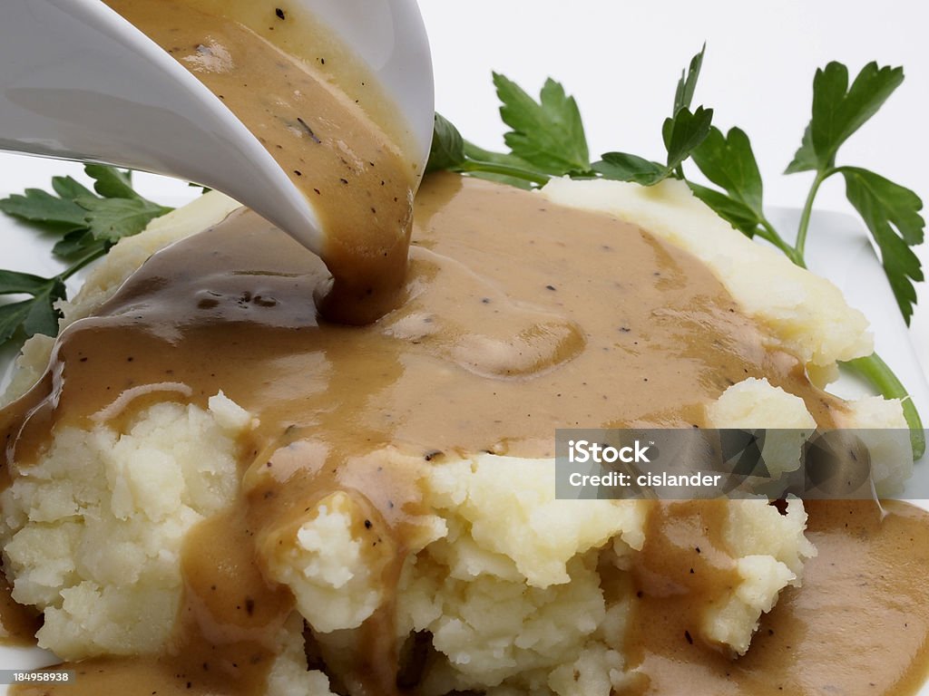 Mashed Potatoes and Gravy Close up of gravy boat pouring over mashed potatoes Gravy Stock Photo