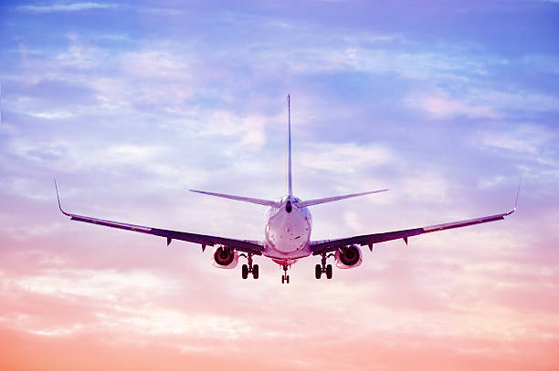 istock Sunlit airplane taking off or lands against evening sky 184958959