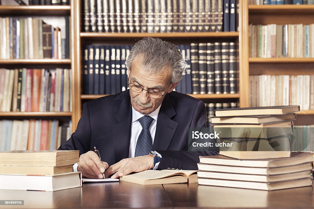 Senior professeur dans la bibliothèque de travail - Photo de Adulte libre de droits
