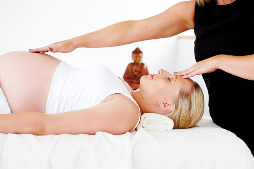 Young pregnant woman at wellness center during a therapuetic body massage
