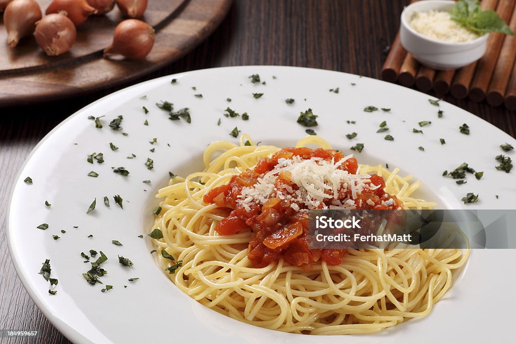 Spaghetti Plate of spaghetti with tomato sauce and ingredients on wooden background. Food image. More photos like this here: Cheese Stock Photo