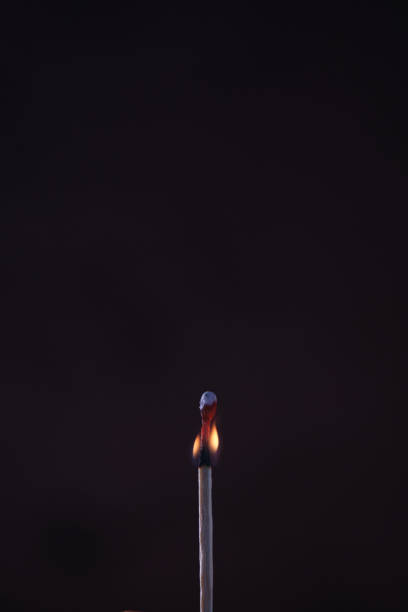 un fiammifero acceso su sfondo scuro - match matchstick dark fire foto e immagini stock