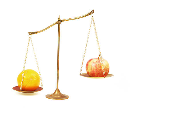 comparar manzanas con naranjas - weight scale apple comparison balance fotografías e imágenes de stock