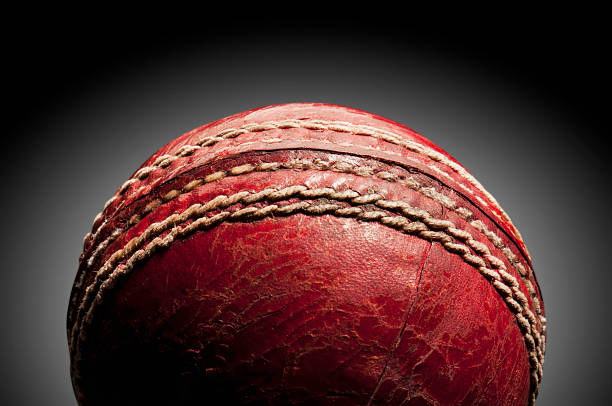 istock Red leather cricket ball on a black background 184960104