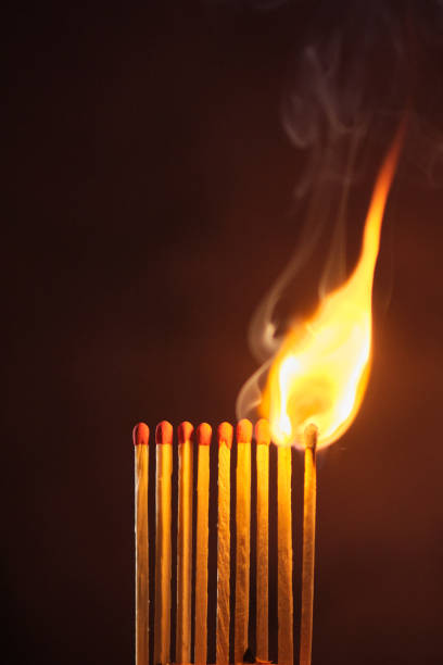 a row of matches are lit on a dark background