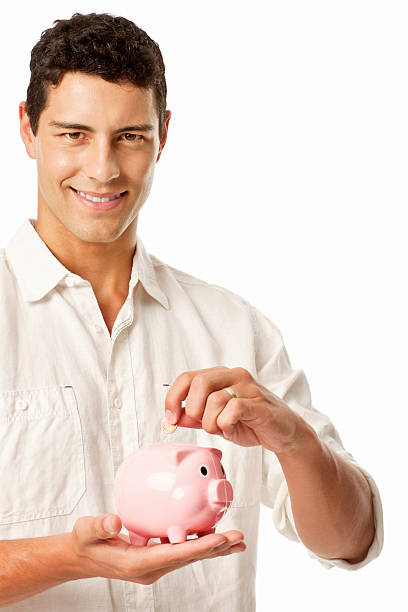 istock Man Placing Coins in a Piggy Bank 184960578