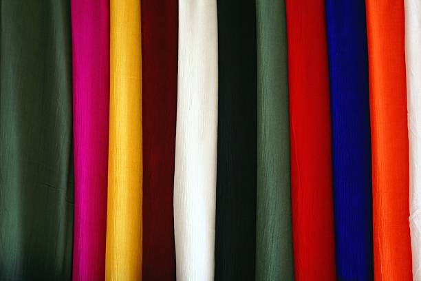Close-up of a colorful collection of fabric swatches hanging in retail rack.