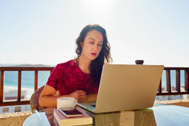 istock Hispanic woman working on laptop on an apartment  balcony 1849619948