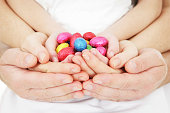 A family portrait of all their hands holding Easter eggs
