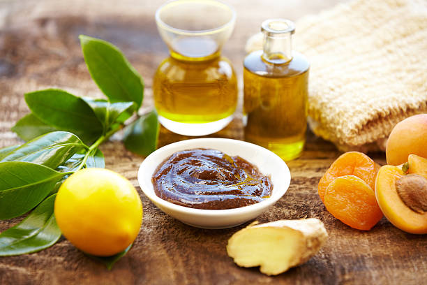 Spa still life with organic scrub, massage oil, apricots, ginger