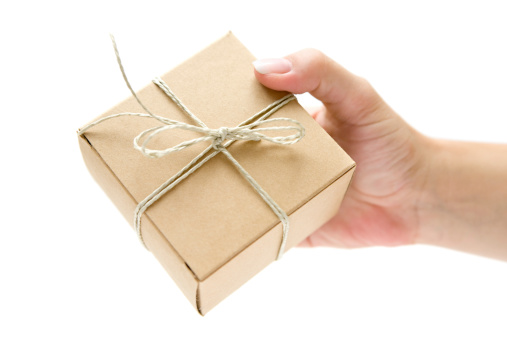 Woman holding a small gift box wrapped in brown paper. Isolated on a white background.