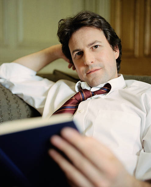 istock Smart businessman relaxing with a book 184963957