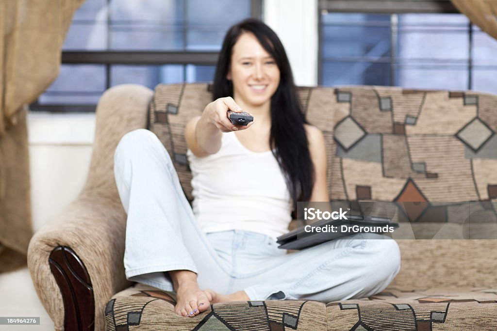 Jovem mulher assistindo TV em casa - Foto de stock de Mesa digital royalty-free