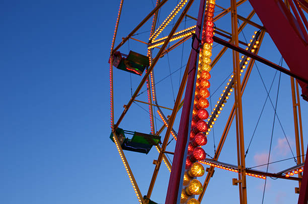 funfair ride podświetlona na zmierzch - carnival spinning built structure frame zdjęcia i obrazy z banku zdjęć