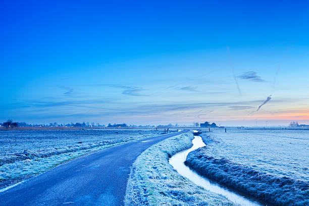 istock Road through typical Dutch polder landscape in winter at dawn 184965691
