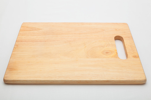 wooden chopping board with handle on continuous tone background