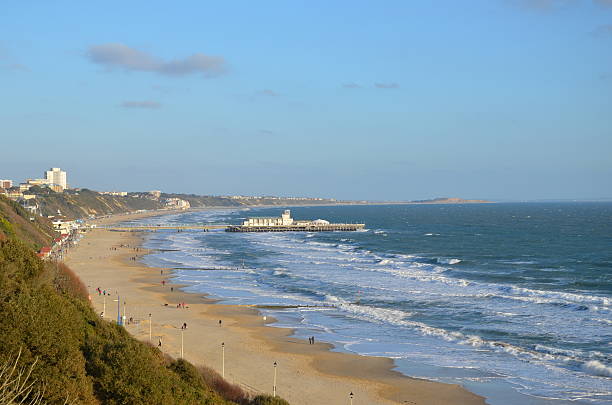 A sunny but windy winters day in Bournemouth in Dorset.  A few people on the beach (too small to be recognisable) and lots of white waves due to high winds.