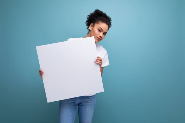 istock young latin brunette female student presenting her study project on a white easel with mockup 1849659643