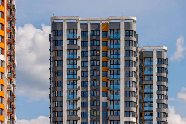 istock freshly built high rise apartment buildings on blue sky background with white clouds 1849660165