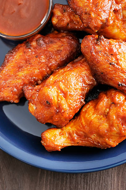 istock Hot and spicy chicken wings served on a blue plate 184966036