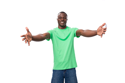 young positive american man in casual t-shirt rejoices on white background.