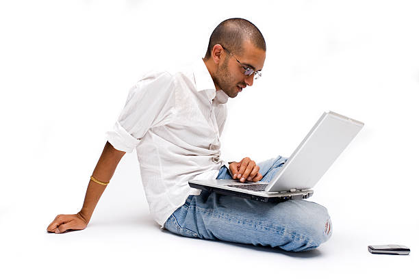 Lounging with a laptop * Young Indian man using modern professional tablet PC. Canon 1Ds Mark 2 file sitting on floor stock pictures, royalty-free photos & images