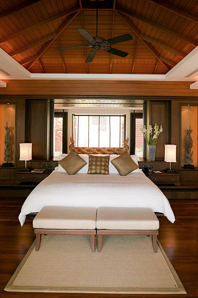 luxury hotel room suite villa phuket thailand hotel suite in villa trisara phuket thailand. the carvings are antique and in lanna style from old thai temples. old fashioned ceiling fans stock pictures, royalty-free photos & images