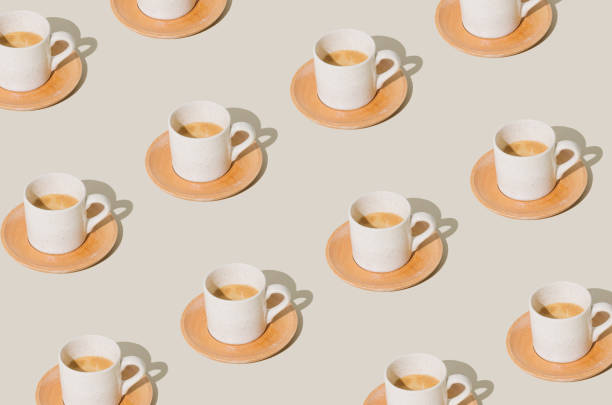 istock Trendy pattern made of cup of coffee on light pastel background. Creative coffee concept. Minimal espresso pattern idea. Coffee aesthetic. 1849676899