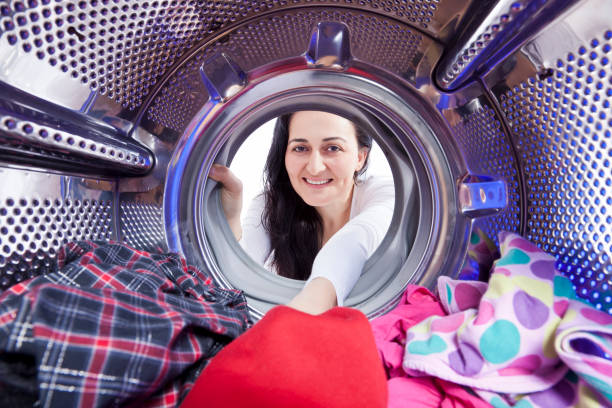 istock Seen from inside the washing machine, women loads laundry 184967748