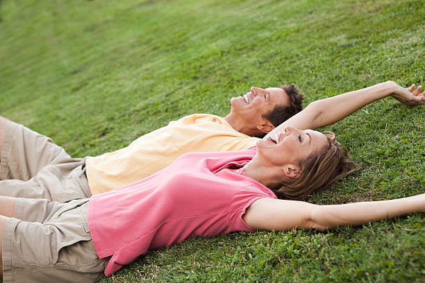 istock Happy mature couple laying on grassy hill 184967837